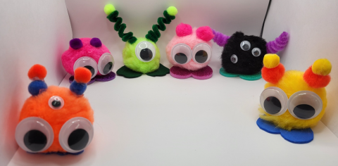 Pom Poms decorated with googly eyes and antennas.