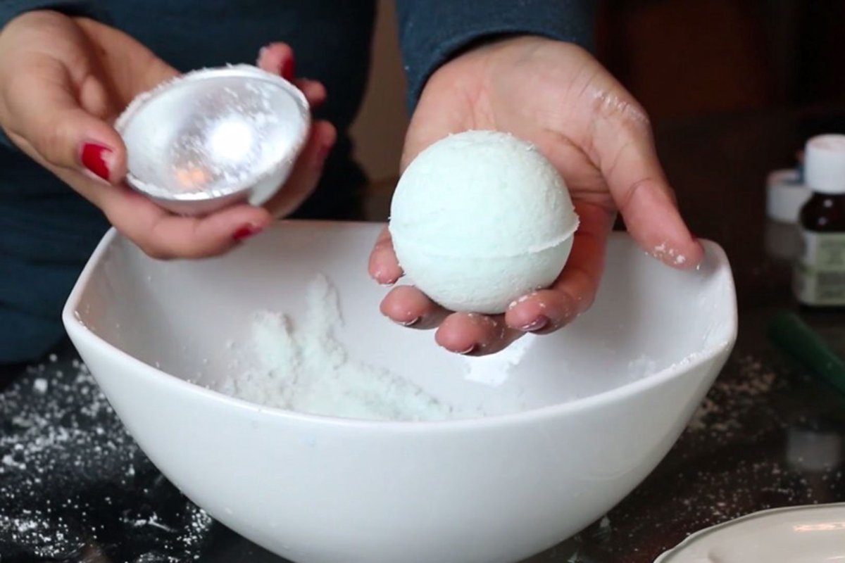 person unmolding a soft green bath bomb