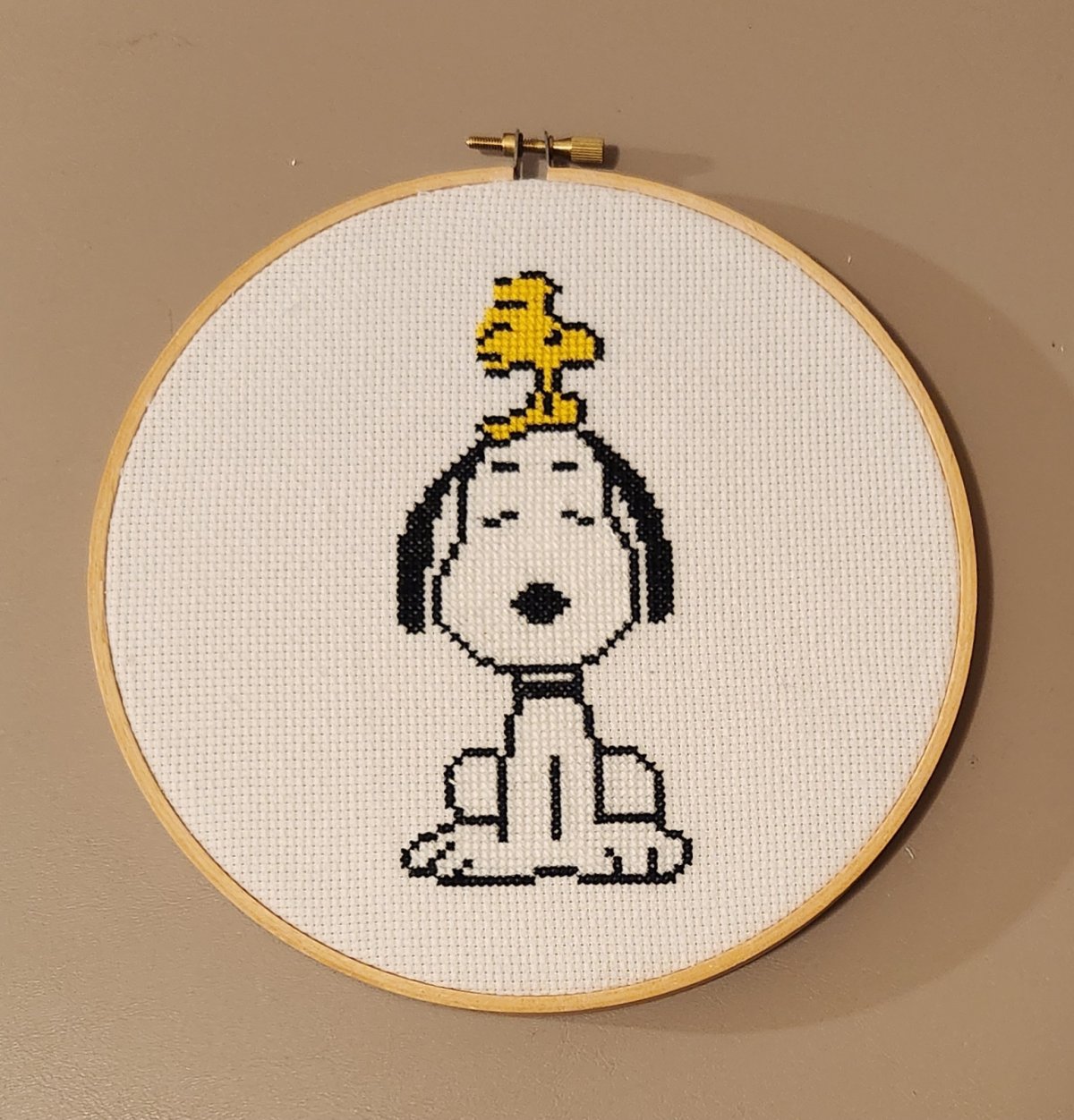 Cross stitch version of Snoopy with Woodstock on his head